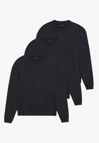 Tre svarta långärmade skjortor, tillverkade i mjukt tyg, med rundad halsringning och åtsittande manschetter. Minimalistisk design utan synliga mönster.