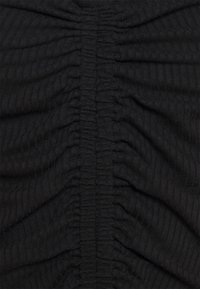 Black ribbed fabric with gathered texture, featuring vertical ruching along the center and smooth surface on either side.