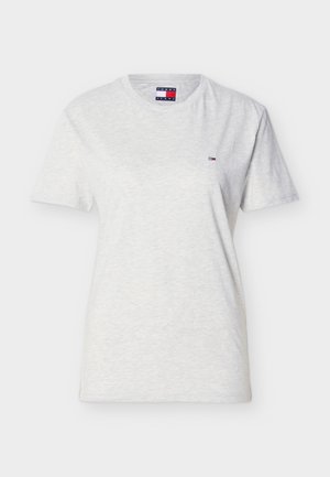 Valkoinen lyhythihainen T-paita, jossa pyöreä pääntie ja pieni Tommy Jeans -logo vasemmassa rinnassa sekä merkitty etiketti kauluksessa.