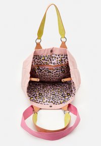 Roze canvas tas met een binnenkant van luipaardprint, met tan leren accenten en groene details op de banden. Open ontwerp met zakken.