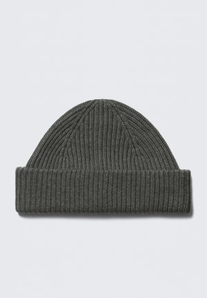 Γκρι πλεκτός σκούφος με ανάγλυφη ριμπ υφή, με διπλωμένη μπάσκα και κωνικό πάνω μέρος. Κατασκευασμένος από μαλακό, ελαστικό υλικό.