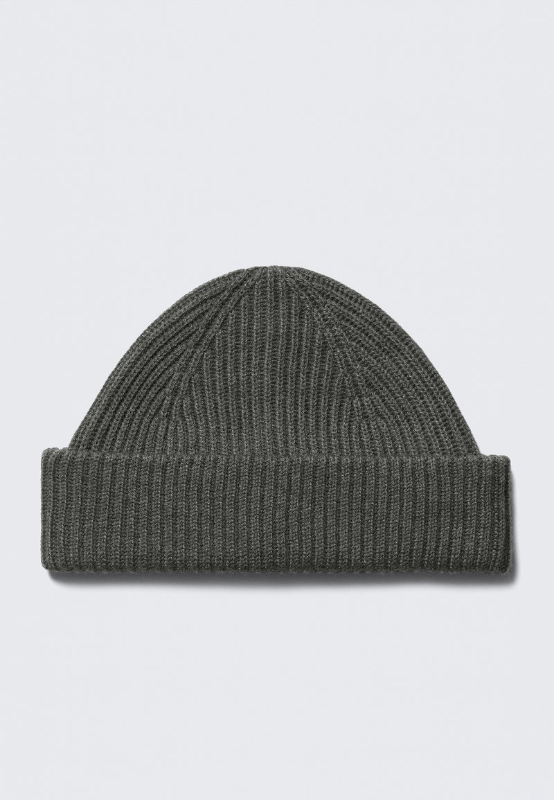 Bonnet en tricot gris avec une texture côtelée, doté d'un revers plié et d'une partie supérieure conique. Fabriqué en matériau doux et extensible.
