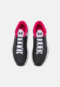 Czarne skórzane trampki z białą środkową podeszwą i różowym podszyciem. Charakteryzują się białym językiem, czarnymi sznurówkami oraz numerem 23 na pięcie.