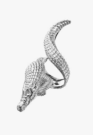 Anillo de plata diseñado como un cocodrilo, con escamas texturizadas, cabeza detallada y una cola retorcida que forma la banda.