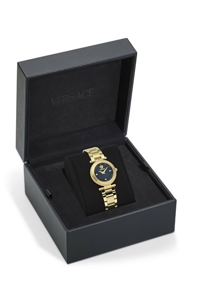 Guldtonet Versace armbåndsur med sort urskive og Medusa-emblem, præsenteret på en sort pude inde i en åben sort præsentationsæske.