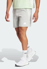 Grå atletiska shorts i ett lättviktigt tyg, med vita tre-stripe detaljer och en adidas-logotyp på vänster ben.