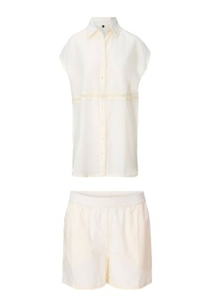 Ärmellose cremefarbene Bluse mit Knöpfen und Spitzenbesatz, kombiniert mit passenden Shorts mit elastischem Bund, beide aus leichtem Stoff gefertigt.