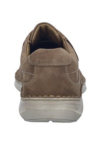 Braune Wildlederschuhe mit runder Zehenform, sichtbaren Nähdetails und einer flexiblen weißen Gummisohle. Die Rückansicht zeigt ein tief ausgeschnittenes Design.