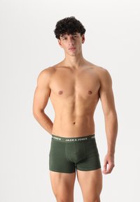 Grüne Baumwoll-Boxershorts mit weichem Elastikbund, auf dem das Logo "JACK & JONES" in Weiß gedruckt ist. Taillierte Passform und kurze Beine.