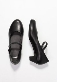 Černé kožené Mary Jane boty s kulatou špičkou, páskem na suchý zip, nízkým podpatkem a hladkým povrchem.