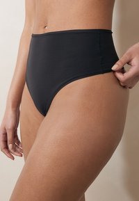 Schwarz hochgeschnittener Bikinihöschen aus glattem, elastischem Stoff. Verfügt über saubere Nähte und eine einfarbige Optik ohne sichtbare Muster.