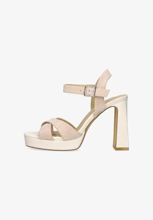 Sandal de tacón alto de ante beige con dos correas cruzadas, correa de tobillo ajustable y tacón cuadrado. Suela de plataforma, acento brillante sutil en el tacón.