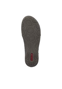 Semelle de chaussure en caoutchouc avec un motif hexagonal texturé ; présente un logo central en rouge ; conçue pour l'adhérence et la durabilité.
