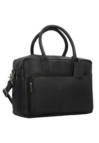 Schwarze Lederhandtasche mit zwei Griffen und abnehmbarem Schultergurt, ausgestattet mit einer vorderen Reißverschlusstasche und einem Gepäckanhänger zur Identifikation.