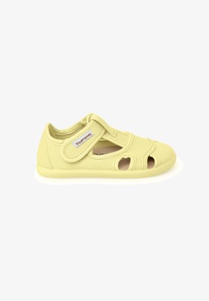 Chaussure jaune clair pour tout-petit avec une bride Velcro et des parties découpées pour la respirabilité, vue de côté sur fond blanc.