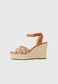 Sandală cu toc wedge, cu o curea din piele maro la gleznă și un exterior din țesătură cu model. Platformă texturată ca o sfoară, cu vârful neted și închis.