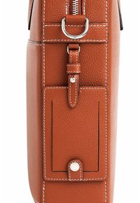 Bolso de cuero marrón texturizado con cierre de cremallera, con costuras blancas, un bolsillo frontal con botón a presión y un acento en metal plateado.