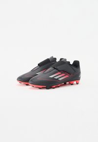 Schwarze Fußballschuhe mit einem strukturierten, stromlinienförmigen Design. Mit roten Akzenten, elastischem Knöchel und sechs Stollen für besseren Halt.