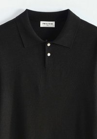 Polo noir avec un col côtelé et deux boutons blancs, étiqueté FRILIVIN, taille M.