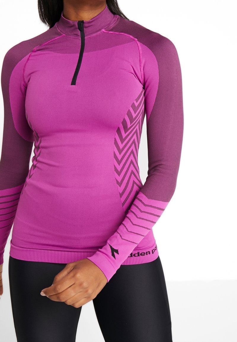 Maglietta aderente a maniche lunghe in un vivace rosa, con zip a quarti, texture a costine, dettagli a motivo chevron e maniche di colore scuro a contrasto.
