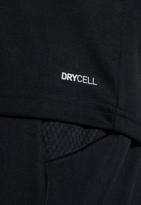 Musta urheilupaita, jossa on valkoinen kosteutta siirtävä DRYCELL-logo. Materiaali on sileä, ja siinä on verkkopaneeli ilmanvaihtoa varten.