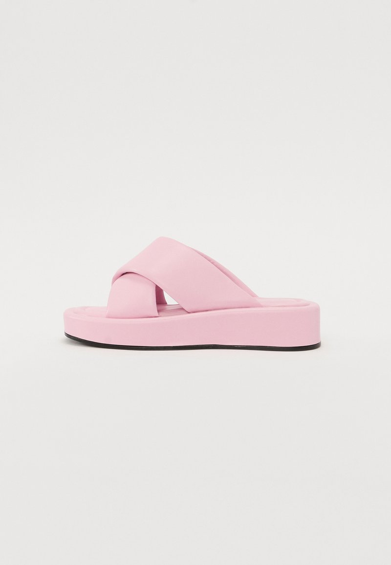 Rosa plattform sandaler med kryssband design, laget av glatt syntetisk materiale og har en tykk såle med sort bunn.