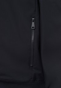 Schwarze Jacken-Sektion mit einer Reißverschlusstasche, glattem Stofftextur und elastischem Saum. Der Reißverschluss hat eine matte schwarze Oberfläche.