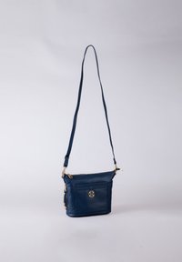 Navy blue crossbody bag made of leather, featuring a gold-tone logo, zippered top, front pocket, and adjustable strap.