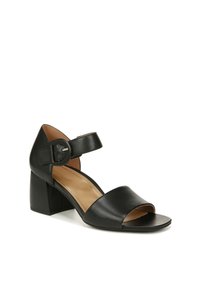 Zwarte leren sandaal met hak, open teen, brede banden en een gespsluiting om de enkel. De blokhak biedt stabiliteit en ondersteuning.