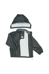 Chaqueta impermeable gris oscuro con capucha desmontable. Presenta puños elásticos, forro gris y un cierre frontal con botones a presión.
