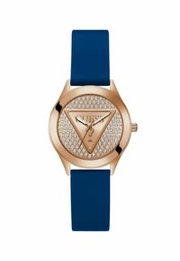 Reloj de oro rosado con una correa de silicona azul, que presenta una esfera con tachuelas y un logo triangular en el centro. Manecillas y acentos minimalistas.