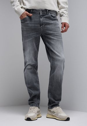 Jeans de mezclilla gris con un diseño de pierna recta, un ligero desvanecimiento y cinco bolsillos, combinados con zapatillas de color claro.
