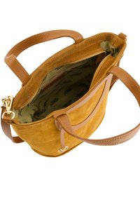 Suède handtas in mosterdgeel met leren accenten. De open bovenkant onthult een patrooninterieur en een ritscompartiment. Twee hengsels zijn bevestigd.