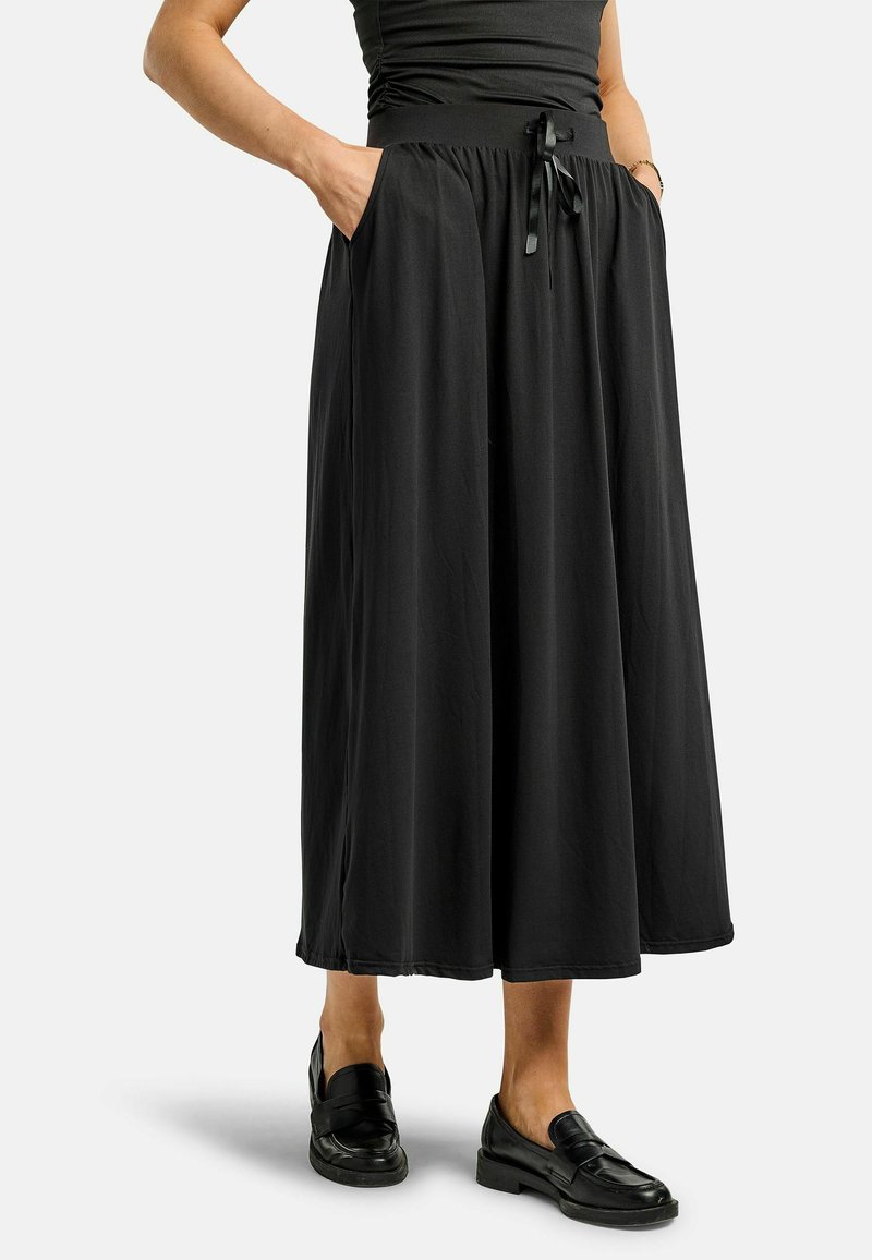 Črna midi krilo z elastičnim pasom, detajlom z vrvico in stranskimi žepi. Izdelano iz lahkega materiala z gladko teksturo.