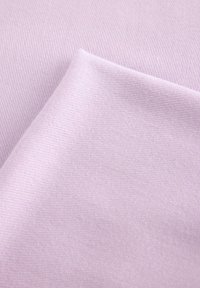 Světlý fialový látkový materiál s jemnou texturovanou tkaninou, který má hladké povrchy. Tkanina je přehnuta, ukazuje měkké záhyby a jemný lesk.