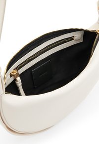 Borsa a tracolla bianca in pelle con zip dorata, fodera interna nera e una tasca con zip interna. Presenta una forma liscia e arrotondata.