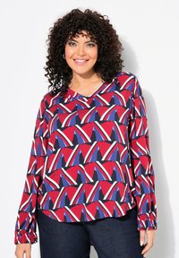 Langermige blouse met een geometrisch patroon in rood, blauw, wit en zwart, met een V-hals en gathered manchetten. Soepele stoftextuur.