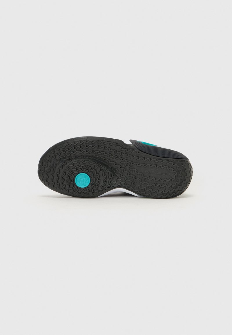 Suela de zapato con banda de rodadura de goma negra, que presenta un acento circular turquesa y ranuras texturizadas para mayor tracción. Presenta mínimos acentos blancos.