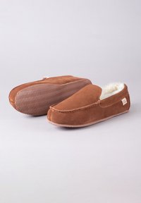 Brown suede slippers with faux fur lining, slip-on design, and herringbone patterned rubber sole, featuring a small brand tag on the side.