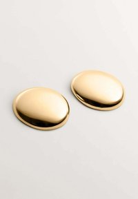 Embellishments metálicos de color dorado con forma suave y redondeada y superficie reflectante, que presentan un diseño sin costuras y bordes curvados.