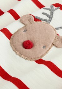 Tessuto bianco con righe rosse che presenta un'applique di faccia di renna color beige, con un naso in feltro rosso, corna grigie e dettagli ricamati.