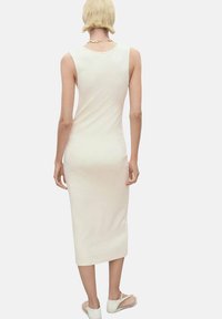 Fitted, cream-colored midi dress with a round neckline, sleeveless design, and a smooth, soft texture. Back view highlights a sleek silhouette.