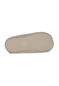 Beige slipper zool met een gestructureerd, geribbeld ontwerp en een zachte voering. Heeft een ronde vorm en een platte onderkant voor stabiliteit.