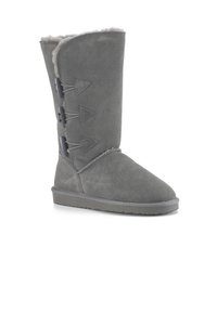 Stivale grigio in suede alto fino al ginocchio con punta arrotondata, rifinitura in pelliccia shearling e tre accenti triangolari sul lato, dotato di suola in gomma piatta.