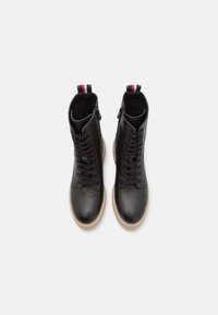 Czarne skórzane botki za kostkę z teksturowanym wykończeniem, z przodem na sznurówki oraz beżową gumową podeszwą, ozdobione kolorowym uchwytem na pięcie.