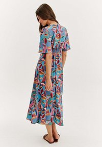 Mít multicolorové midi šaty s květinovým vzorem, krátkými rukávy, smockovaným zadním dílem a splývavou sukní vyrobenou z lehkého materiálu.