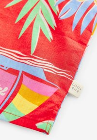 Rode stof met kleurrijke bloemen- en botenpatronen. Bevat groene bladeren, roze en gele accenten, en een klein "Little Bird" label.