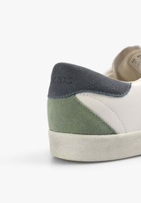 Sneaker con corpo in pelle bianca, dettagli in suede grigio e verde, una suola in gomma testurizzata e un collo imbottito per il comfort.