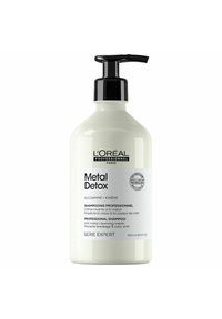 Witte shampoofles met een zwarte pompdispenser, gelabeld "Metal Detox" en bevat tekst in zowel het Engels als het Frans. Bevat 500 ml.