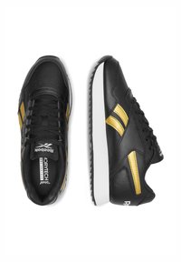 Čierne kožené tenisky s zlatými akcentmi a bielou podrážkou. Majú okrúhly špičku, šnurovací dizajn a textúrovanú podrážku pre lepšiu priľnavosť.